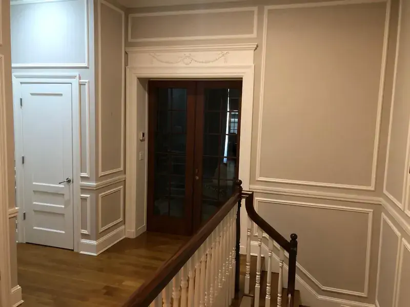 Hallway with classic mahogany doors, white trim and baseboard detail