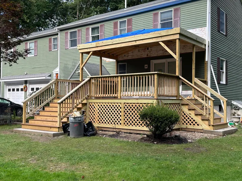 The finished covered deck with stairs, railing and lattice skirting