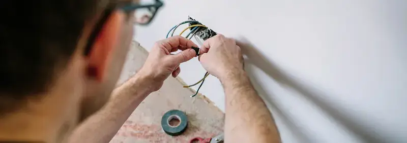 Electrician installing an electrical outlet in a wall