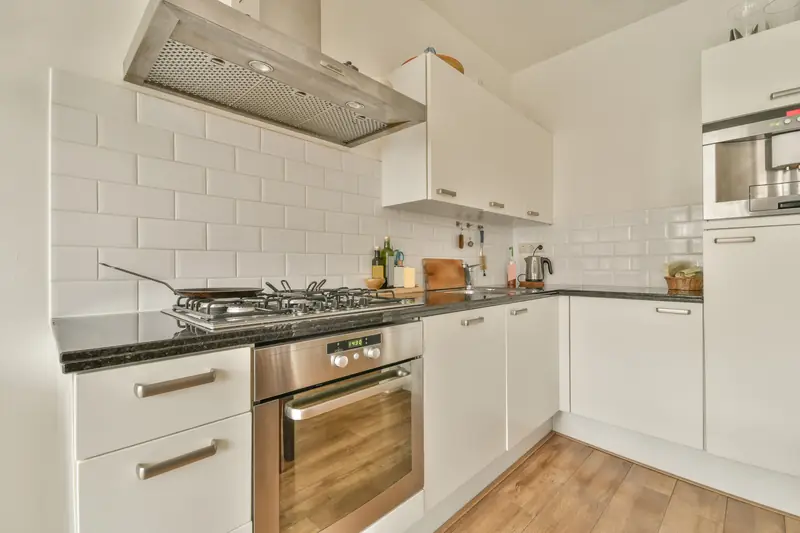 White kitchen with subway tile backsplash and range hood
