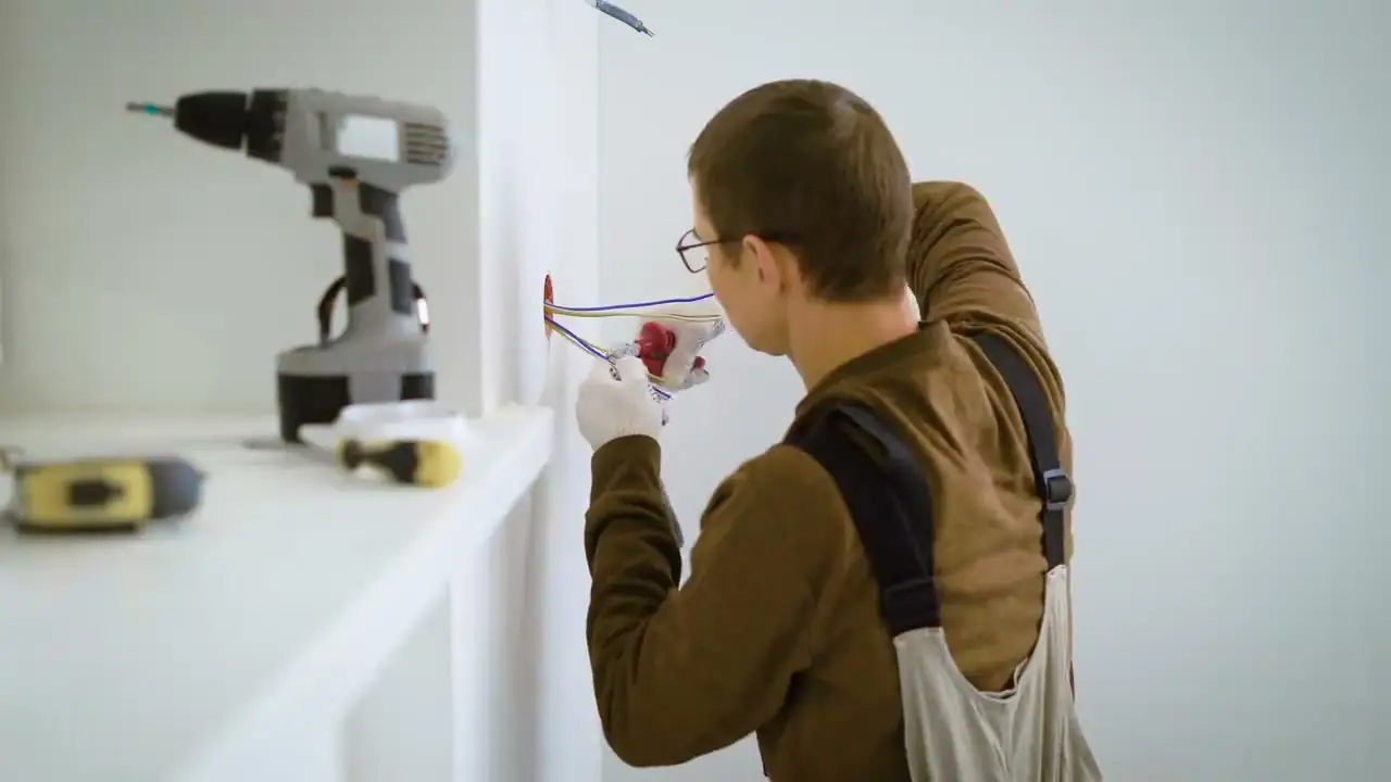 Electrician installing an electrical outlet in a wall